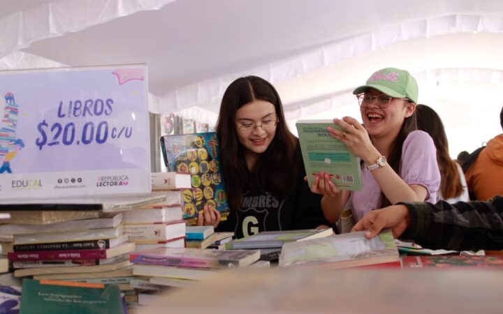 Jóvenes revisan libros durante el 22º Gran Remate de Libros, Discos y Películas en el Monumento a la Revolución
